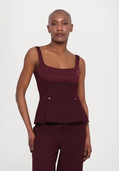 Haut peplum bordeaux avec un décolleté carré et des larges bretelles, présentant des accents décoratifs en argent à la taille et une texture de tissu lisse.