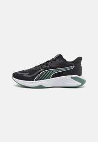 Baskets de sport noires avec des accents verts, un dessus en tissu texturé, un col rembourré et une semelle intermédiaire blanche rembourrée. Dotées d'une semelle extérieure en caoutchouc.
