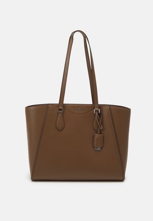 Sac cabas en cuir marron avec bretelles doubles et une petite étiquette suspendue sur le côté droit.