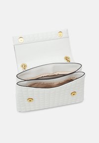 Borsa a tracolla bianca trapuntata con finitura in pelle liscia, accessori in oro, due scomparti e foderatura interna leggermente patternizzata.