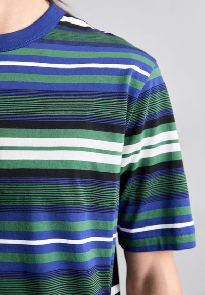 T-shirt à manches courtes en coton, avec des rayures horizontales dans des tons de bleu, vert, noir et blanc. Encolure ronde avec un bord côtelé.