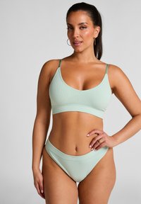 Mintgroene geribbelde bikini set met verstelbare bandjes; de top heeft een brede band en een V-hals, terwijl de onderkant een hoge uitsnede heeft.
