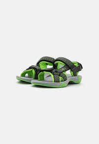 Sportsandaler med en svart och grön design, syntetiska remmar med strukturerad yta, samt en grå gummisula för grepp.