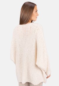 Dicker Strickpullover in Creme, mit lockerer Passform, weiten Ärmeln und einem strukturierten Muster. Leichtes Material mit entspanntem Schnitt.