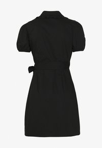 Robe noire avec un col, des manches bouffantes courtes, une ceinture à la taille et un accent froncé le long du col. Texture de tissu lisse.