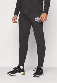 Zwarte katoenen joggers met een slim fit, voorzien van een wit PUMA-logo op de linkerdij en ribgebreide boorden voor een aansluitende pasvorm.