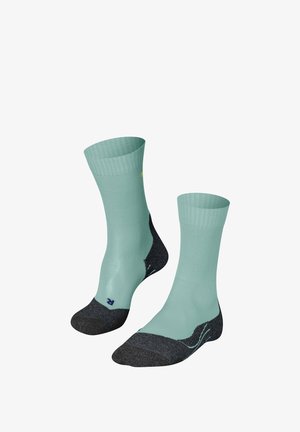 Mintgroene sportkousen met een geribd ontwerp, contrasterende donkergrijze hiel en teen, en subtiele merkbranding aan de zijkant.