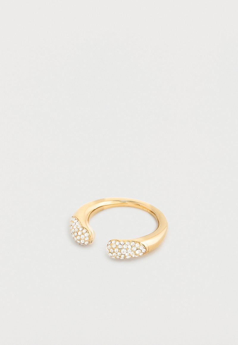 Χρυσό ανοιχτό δαχτυλίδι με δύο στρογγυλεμένα άκρα, καθένα διακοσμημένο με μικρούς λευκούς πολύτιμους λίθους, σε απλό ανοιχτό γκρι φόντο.