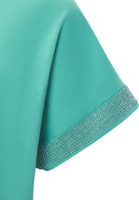 Teal short-sleeved garment with a smooth texture, featuring a decorative band of silver studs along the sleeve edge.