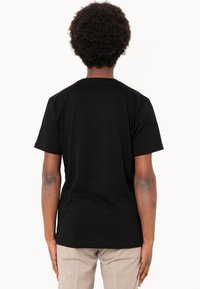Black cotton t-shirt with short sleeves and a classic crew neck design, viewed from the back, featuring soft texture and a tailored fit.