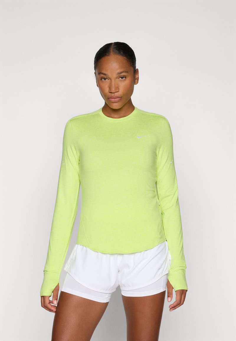 Maglietta sportiva a maniche lunghe di un vivace verde neon, realizzata in materiale leggero con scollatura rotonda e design aderente. Presenta un logo discreto.
