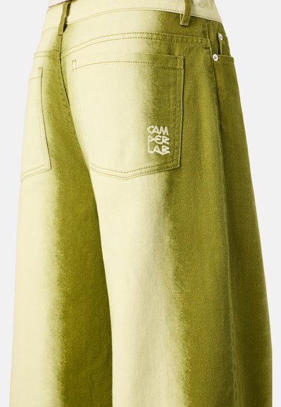 Vaqueros verde oliva con un diseño de degradado de claro a oscuro. Cuenta con bolsillos laterales y traseros, con "CAMPERLAB" bordado en la parte trasera.