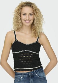 Fekete horgolt crop top fehér díszítéssel, feszes fazonnal, nyitott kötött részletekkel és állítható spagetti pántokkal.