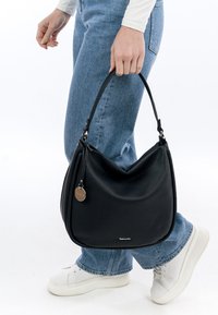 Czarna skórzana torba hobo o textured powierzchni, z srebrnym okuciem i bocznym zamkiem błyskawicznym. Regulowany uchwyt umożliwia różnorodne opcje noszenia.