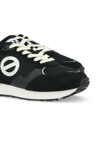 Scarpe da ginnastica nere realizzate con una combinazione di materiali in rete e suede. I lacci bianchi, il dettaglio del logo e una suola in gomma a contrasto completano il design.