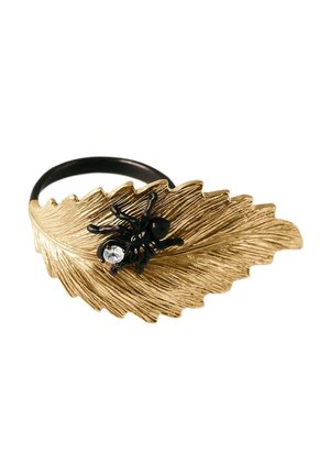 Anillo negro con un diseño texturizado de hoja dorada y una pequeña araña negra con una gema clara sobre la hoja.
