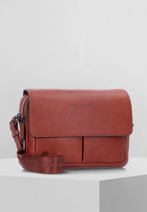 Borsa a spalla in pelle marrone con patta ripiegabile, due tasche frontali, tracolla regolabile e logo in rilievo sul fronte. Texture liscia.