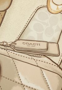 Borsa a tracolla in pelle beige con texture trapuntata, caratterizzata da un'etichetta Coach e accessori in tonalità oro, che mette in risalto sottili dettagli di cucitura.