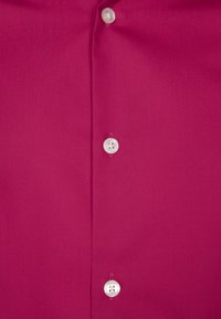 Koszula zapinana na guziki w kolorze fuksji o gładkiej fakturze, z pięcioma białymi guzikami i klasycznym kołnierzem.