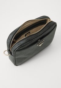Borsa in pelle sintetica nera con texture, zip e dettagli dorati, con un ampio interno e un logo accentuato sul davanti.