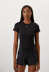 Camisola atlética preta de mangas curtas com design ajustado e painéis laterais texturizados, combinada com calções atléticos pretos, ambos feitos de tecido suave.