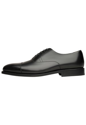 Schwarze Leder-Die Schuhe mit glatter Oberfläche, abgerundetem Zeh, minimalistischen Design und sechs Ösen für die Schnürung. Robuste schwarze Sohle.