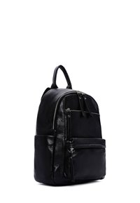 Zaino in pelle nera con una texture liscia, dotato di numerosi scomparti con zip e una forma arrotondata. Include spallacci regolabili e imbottiti.