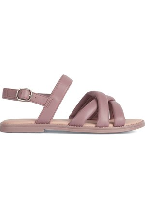 Sandalias de cuero rosa con tiras cruzadas, correa ajustable en el tobillo, suela plana y textura suave. Diseño simple con detalles mínimos en el hardware.