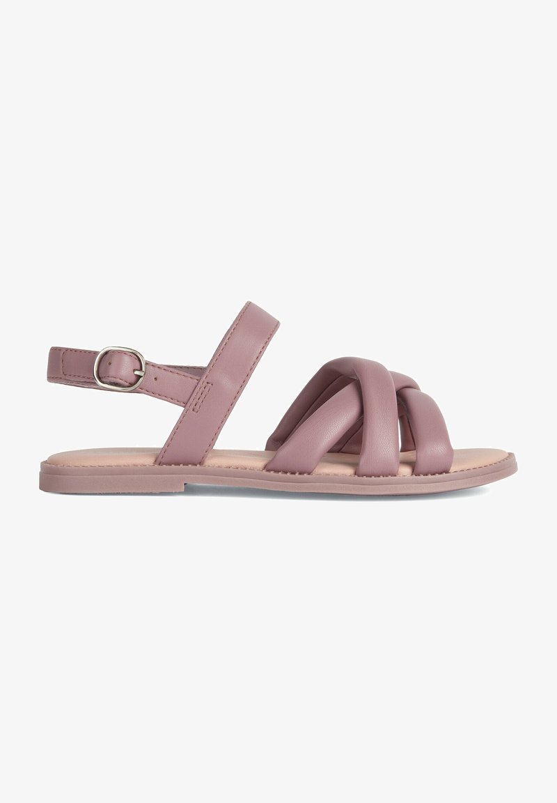 Sandalias de cuero rosa con tiras cruzadas, correa ajustable en el tobillo, suela plana y textura suave. Diseño simple con detalles mínimos en el hardware.