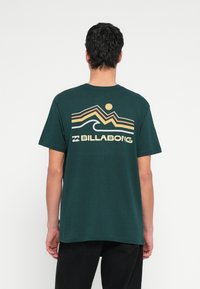 Πράσινο βαμβακερό T-shirt με γραφικό ρετρό στυλ στην πλάτη που απεικονίζει βουνά, ήλιο και κύματα, με την ένδειξη "BILLABONG". Με κοντά μανίκια.