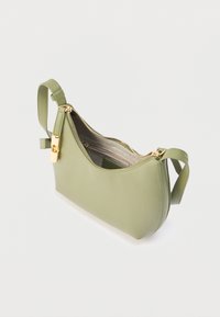Ανοιχτοπράσινη δερμάτινη τσάντα ώμου με φερμουάρ και κλείδωμα σε χρυσό τόνο, ανοιχτή με υφασμάτινη εσωτερική επένδυση και εσωτερική τσέπη με φερμουάρ, σε λευκό φόντο.