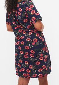 Vestido floral con fondo azul marino y flores rosas y amarillas. Mangas cortas, diseño hasta la rodilla, tejido suave y corte relajado.