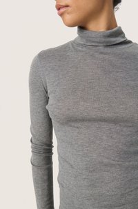 Grå polotröja i mjukt, stretchigt tyg. Har långa ärmar och en figurnära design, med en slät yta och minimala detaljer.