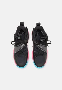 Zapatillas deportivas negras con acentos en rosa y azul, que cuentan con paneles texturizados, diseño de cordones y un prominente eslogan "Just Do It" en los lados.