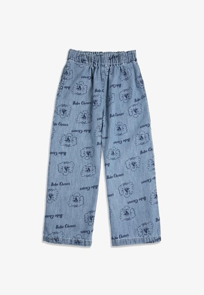 Pantalon en denim bleu clair avec taille élastique, présentant un motif répété de visages de moutons de dessin animé bleu foncé et le texte « Bobo Choses ».