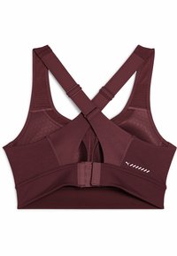 Reggiseno sportivo color mogano con spalline incrociate, un pannello in rete per la traspirabilità e chiusura con ganci e occhielli sul retro.