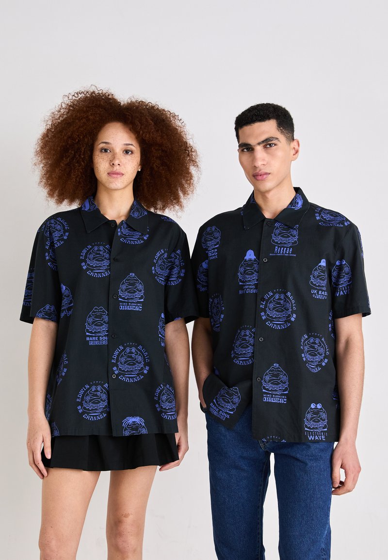 Korte mouwen, geknoopte shirts in zwart met blauwe grafische ontwerpen van gezichten en muziekgerelateerde teksten. De stof lijkt licht en zacht te zijn.