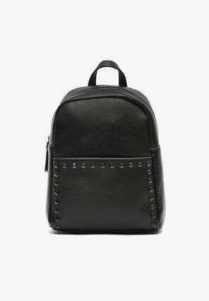 Mochila de cuero negra con acabado texturizado, parte superior redondeada, cierre de cremallera y acentos de tachuelas a lo largo del panel frontal. Incluye doble asa superior.