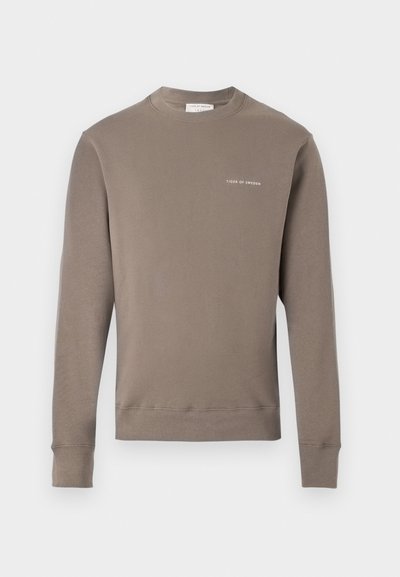 Ilgi piedurkņu taupe krēklis ar ribotām aprocēm un apakšmalu, ar mazu baltu "Tiger of Sweden" logotipu uz kreisā krūšu.