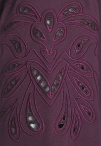 Tela morada con intrincados bordados de flores recortadas y una textura suave. Los patrones detallados realzan el atractivo visual.