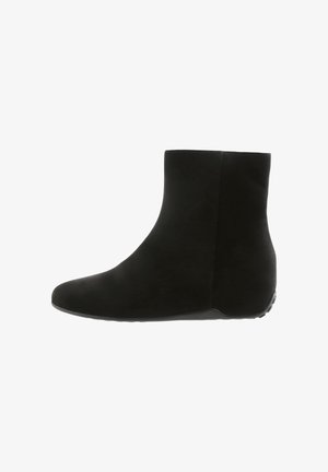 Bottine noire avec une texture en daim lisse, bout arrondi et un petit talon en coin discret. Caractéristiques d'un design simple et homogène avec une semelle en caoutchouc.