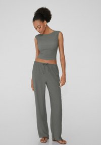 Ensemble deux pièces gris composé d'un crop top ajusté à col rond et de pantalons amples taille haute avec un cordon de serrage.