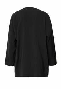 Černý oversized top s kulatým výstřihem, tříčtvrtečními rukávy a hladkým, lehkým materiálem. Bez švového oproti a bez výrazných vzorů.