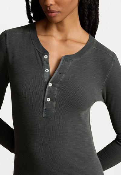 Donkergrijze langemouwen henley shirt van ribstof, met een ronde halslijn, een placket met vijf knopen en subtiele stiksels.