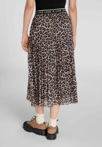 Harmahaara leopardikuosiska, jossa on joustava vyötärö ja "Rakkaus"-kirjailu. Yhdistettynä paksupohjaisiin ruskeisiin alushousuihin ja valkoisiin sukkiin.