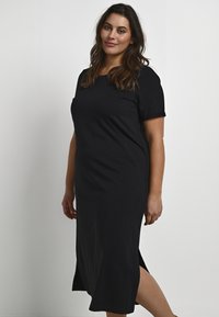 Vestido midi negro de manga corta con cuello redondo, con aberturas laterales para mayor comodidad, hecho de una tela suave y ligera. Textura suave, diseño casual.