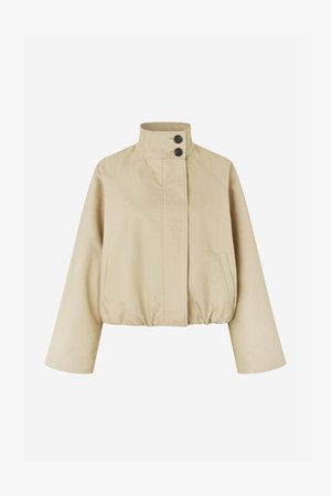 Beige cropped jacket made of smooth fabric, featuring a high collar, two black buttons, and side pockets with a gathered hem.