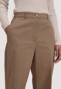 lichtbruine broeken van een katoenmix, met een rechte cut, voorzakken en een enkele knoopsluiting bij de taille.