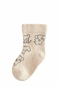 Beige bomuldsokker med ribbet tekstur, prydet med sorte elefantdesigns spredt over overfladen. Ankellængde stil.