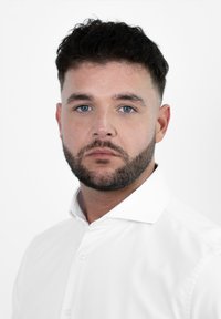 Formele witte overhemden met een gespreide kraag, een gladde stof, een getailleerd ontwerp en een subtiele glans, gedragen door een man met kort, donker haar.